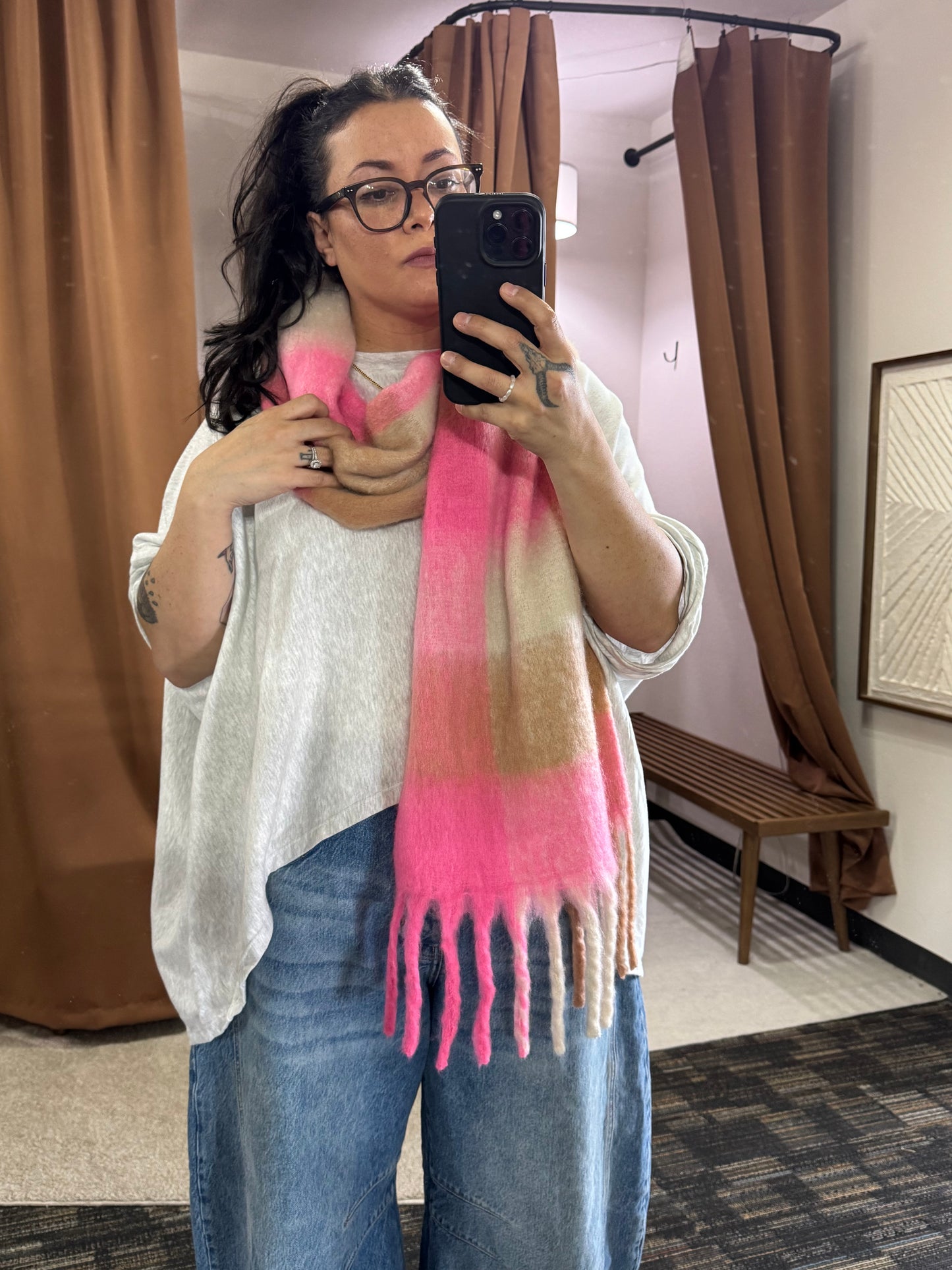 Showcasing a wide and long scarf that has multi color pattern featuring bright pink, beige, and cream. It’s a bold choice for spring but the neutral colors make it so approachable and casual to wear. 