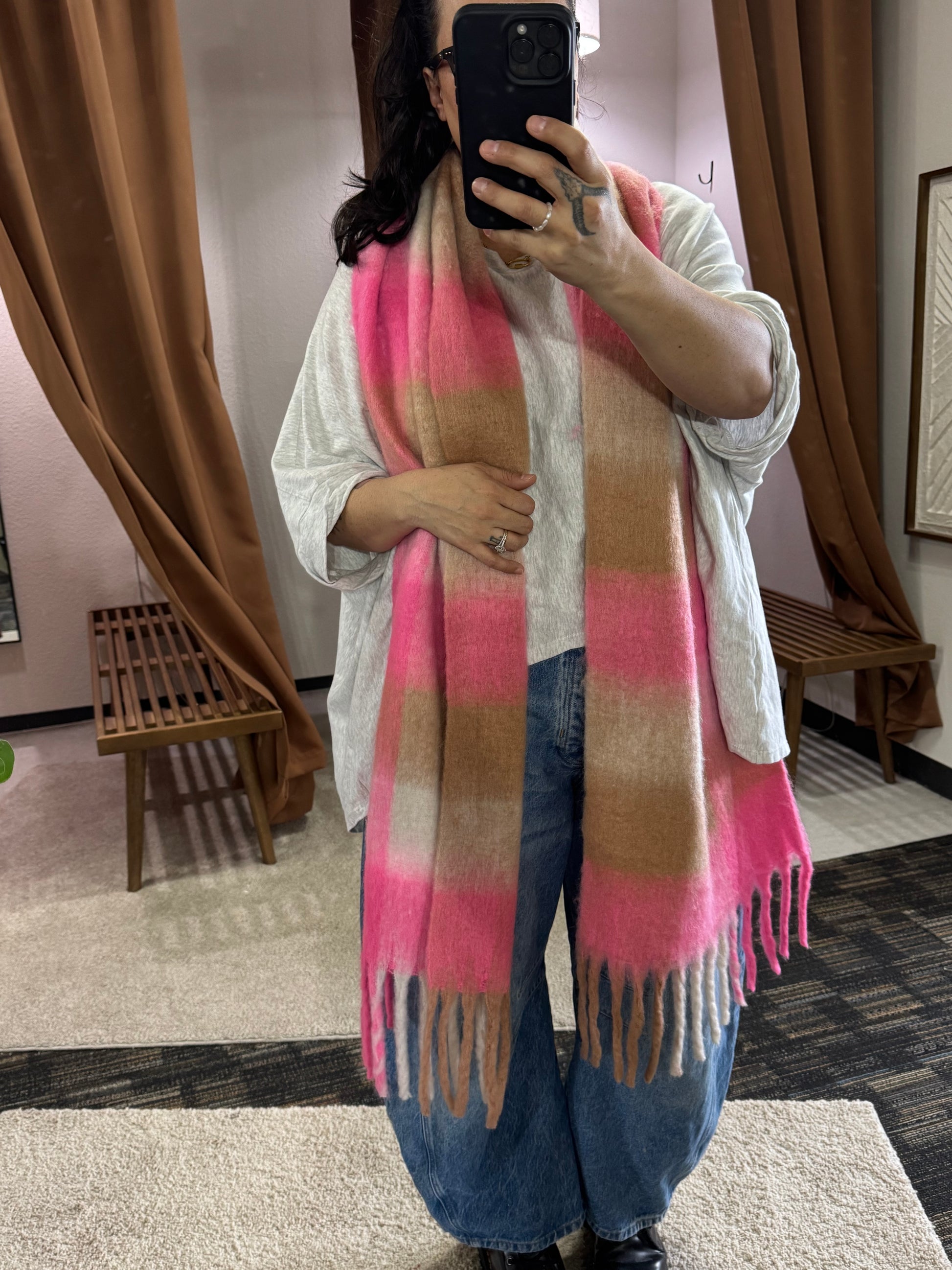 Showcasing a wide and long scarf that has multi color pattern featuring bright pink, beige, and cream. It’s a bold choice for spring but the neutral colors make it so approachable and casual to wear. 