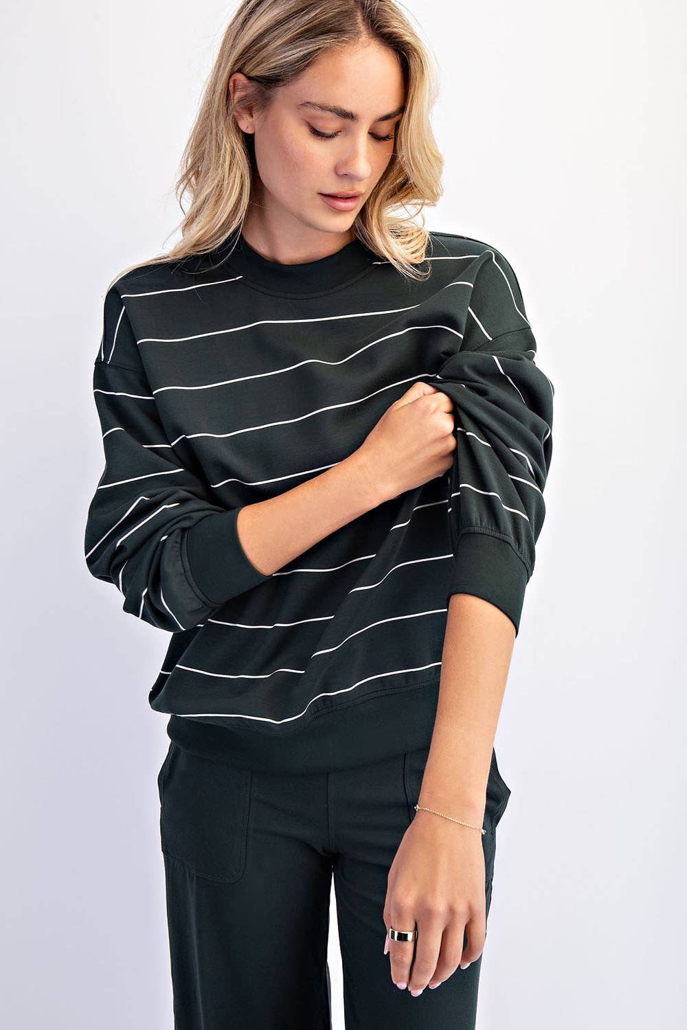Woman wearing a dark green and white horizontal stripe long sleeve top